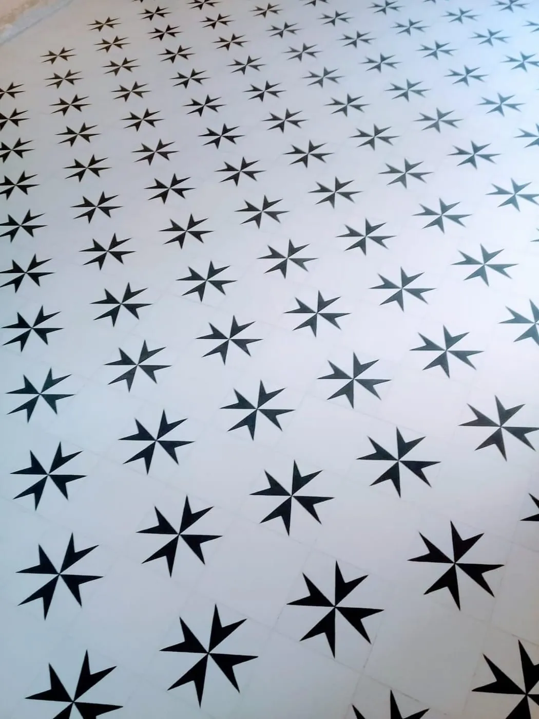 A crisp black star motif repeating across white cement tiles