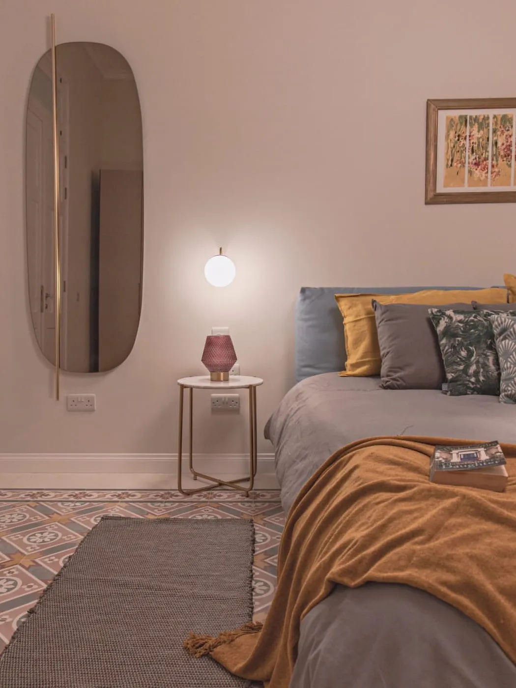 A soft pink bedroom over a patterned cement tile floor