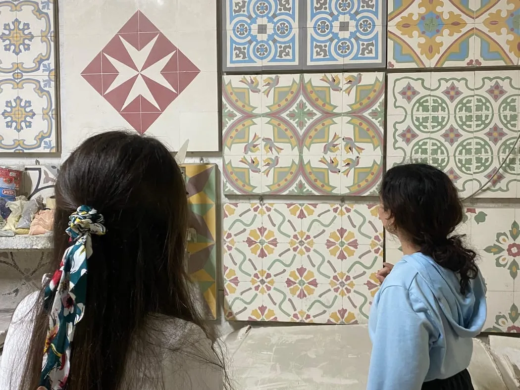 A wall of handmade Maltese cement tile patterns on display