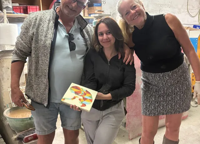 Visitors showing off a finished handmade tile